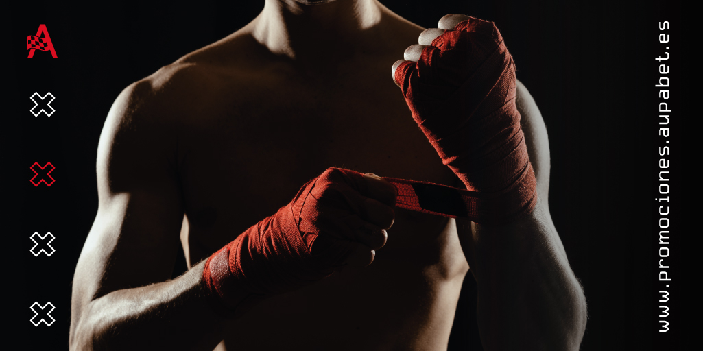 Boxeador concentrado ajustándose las vendas de las manos antes del combate